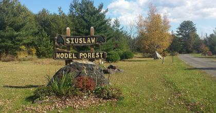 welcome sign for the siuslaw model forest