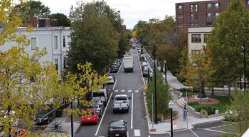 urban landscape with a street, building, and some trees. 